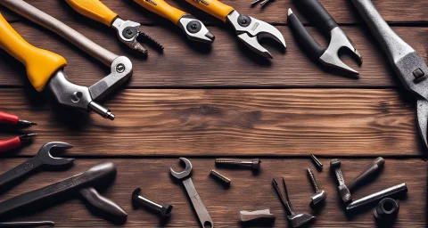 The image shows a set of tools including a wrench, screwdriver, pliers, and hammer on a wooden workbench in a workshop.